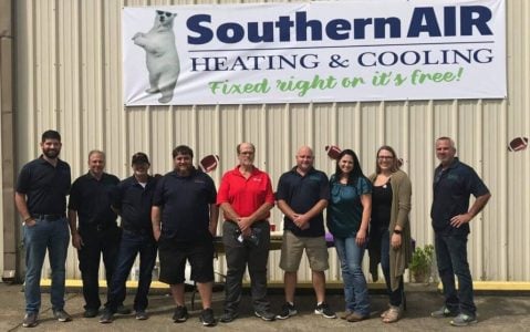 Southern Air Heating & Cooling team members standing in front of company building with logo and tagline visible.