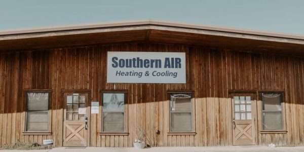 Wooden storefront building with Southern AIR Heating & Cooling sign and beige lower panels.