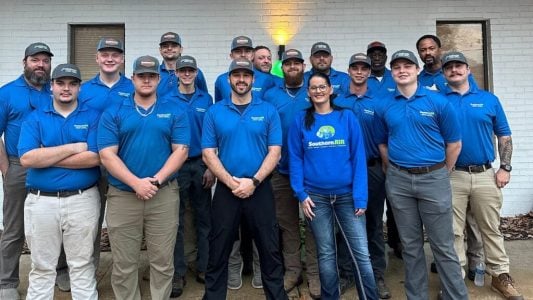 Team of HVAC and electrical professionals wearing blue Southern Air uniforms posing together indoors.