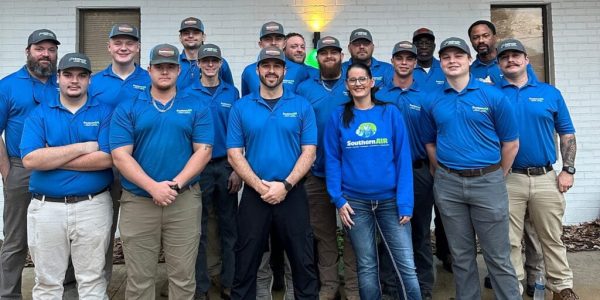 Team of HVAC and electrical professionals wearing blue Southern Air uniforms posing together indoors.